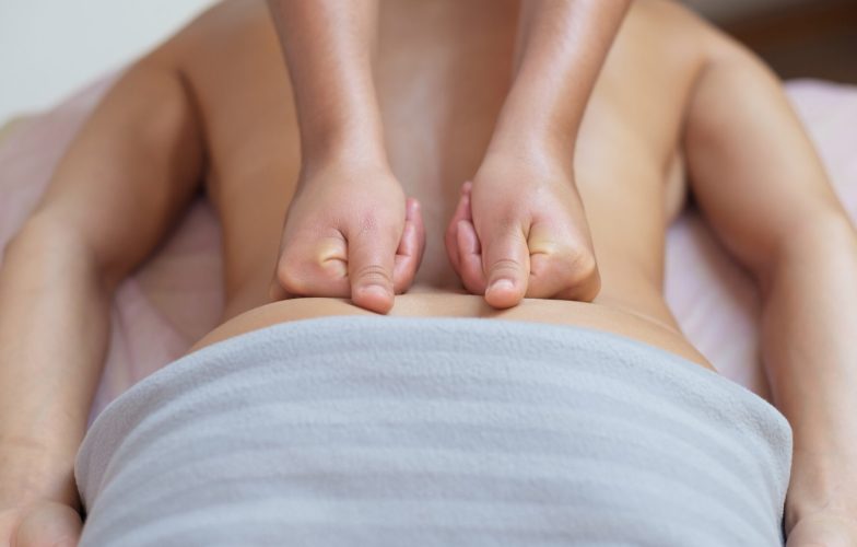 Caucasian woman getting a back massage in the spa salon. Body care concept.